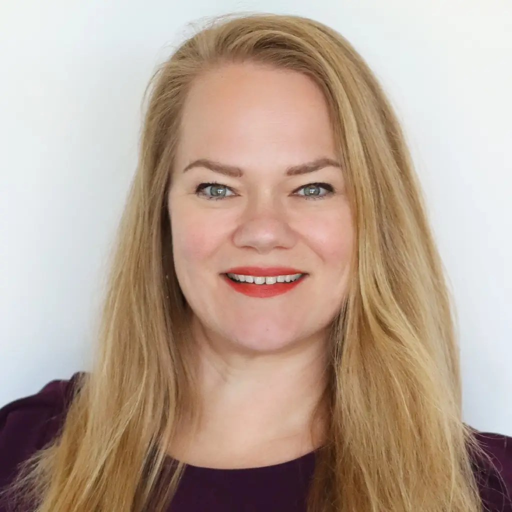 Headshot of the director of strategic communications, smiling with long blonde hair against a light background.